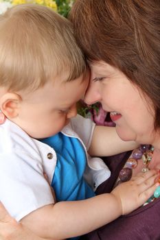 Beautiful blond baby boy sitting by his grandmother