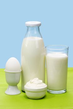 Fres milk, curd cheese and egg over green and blue background