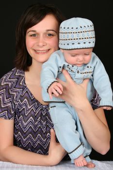 Beautiful brunette mother with her baby boy dressed in blue 