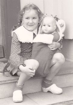 old photo of girl with her doll