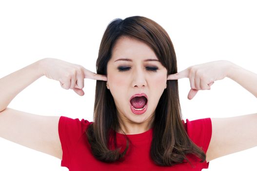 Portrait of a frustrated young woman with fingers in her ears, isolated on white background.