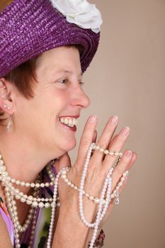 Adult female wearing a purple hat and pearls