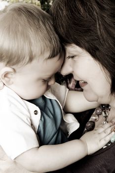 Beautiful blond baby boy sitting by his grandmother