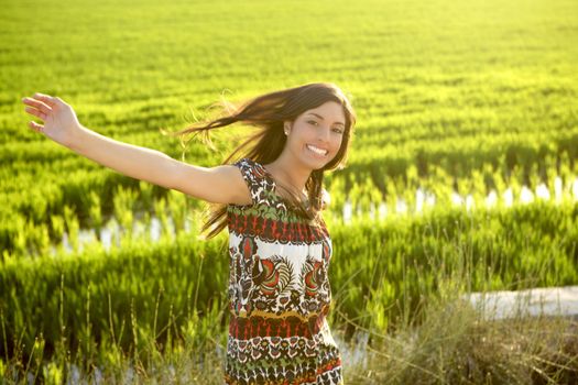 Beautiful brunette indian young woman in the green rice fields meadow