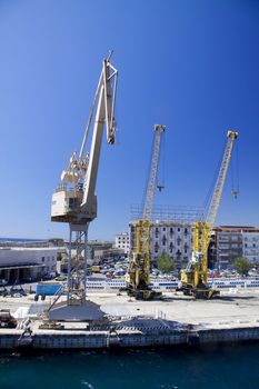 Three industrial cranes at the harbor in Messina Sicily