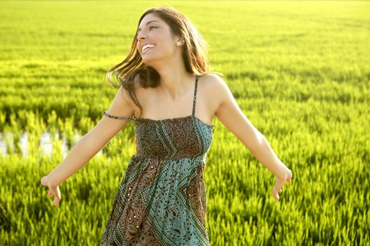 Beautiful brunette indian young woman in the green rice fields meadow