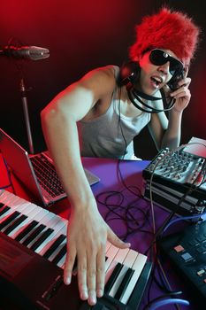 Dj with colorful light and music mixing digital equipment