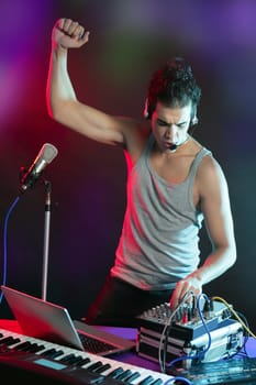 Dj with colorful light and music mixing digital equipment