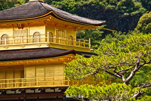 Close up of Kinkaku-ji temple, a Zen Buddhist sanctuary in Kyoto, Japan. The top two stories of the pavilion are covered with pure gold leaf.