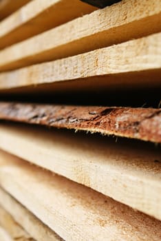 Stacked wooden planks in various shapes of brown