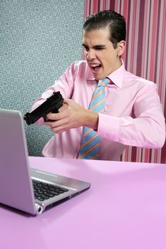businessman young shooting handgun with computer pink bacground