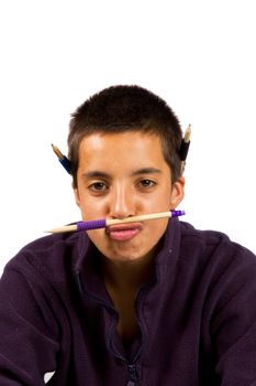 Pakistani schoolboy is playing funny with pencils on white