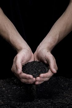 Male hands holding some fresh soil. Hands are dirty.