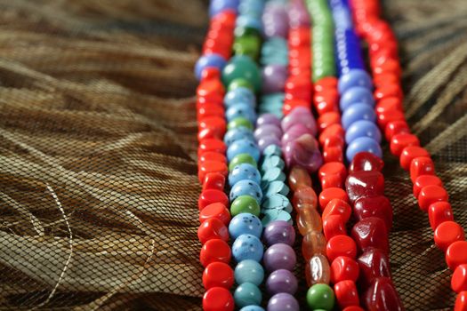 Color stones jewelry necklaces over natural straw and tulle background