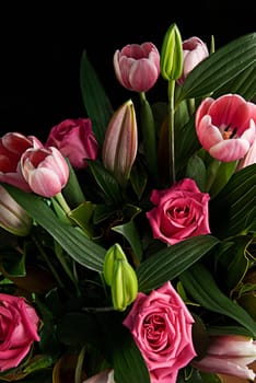 A bunch of flowers with green leaves. Tulips, roses etc.