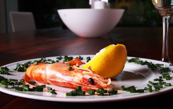 Giant shrimp on a plate, a glass of champagne and a lemmon