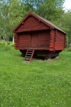 A old red wooden log house, summer or spring time in sweden.