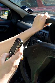 Woman sending a text message while driving a car
