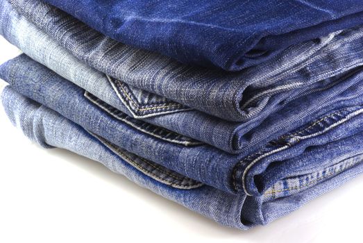 Five pairs of jeans, isolated on a white background.
