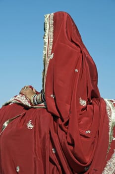 Indian Lady wearing ornately embroidered red sari, Jaisalmer, Rajasthan, India.