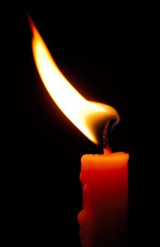 Image shows a red candle with a shimmering flame