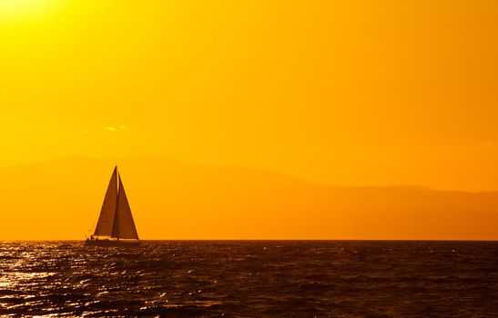 A sailing boat travelling the Mediterranean late in the afternoon