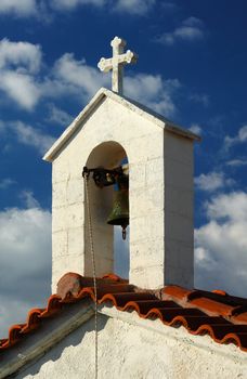 A Greek countryside chapel against a blue cloudy sky