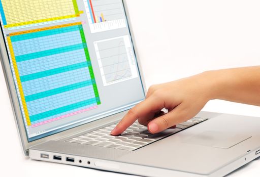 Image shows a finger pressing a key on a contemporary laptop  displaying a business spreadsheet