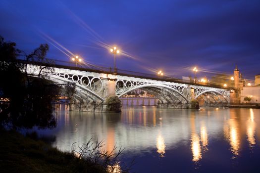 Panorama of Seville riverside at down under the Triana Bridge, the oldest bridge of Seville.