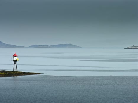 Land marker bouy in norway sea in a foggy day