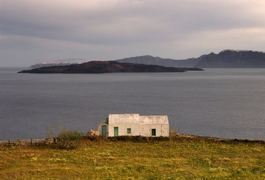 Image shows a small farm house on the island of Santorini, Greece