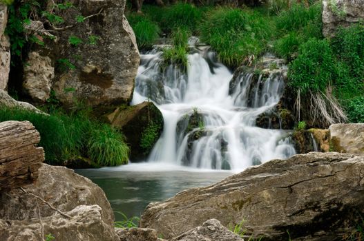Image shows a small waterfall in a rocky landscape