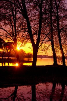 Evening sunset reflections on the lake in spring. Transparent water. Wonderful view.