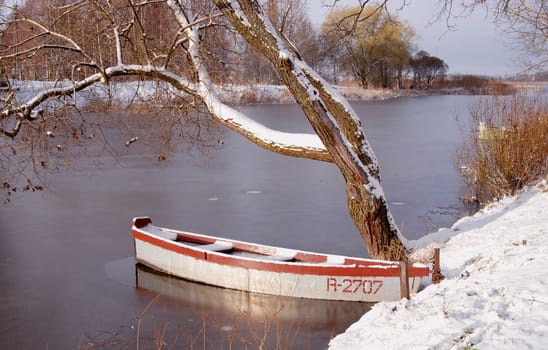 The first snow and ice on the river and boat.