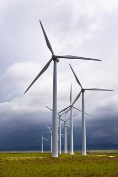 Wind turbines generating electricity in a stormy weather.