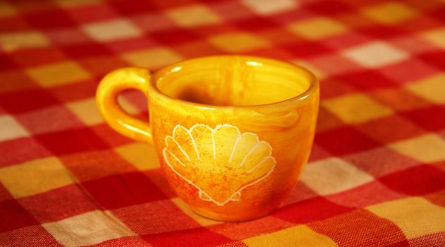 Yellow mug on colored tablecloth