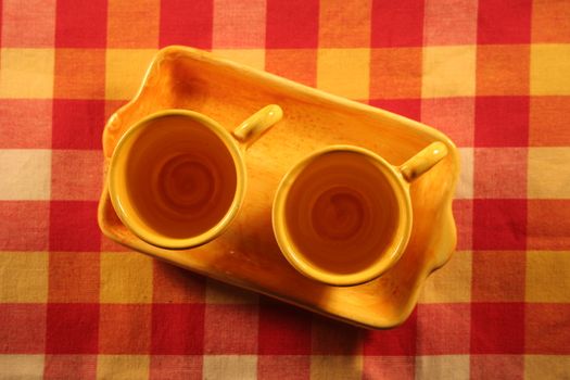 Yellow mugs on tablecloth