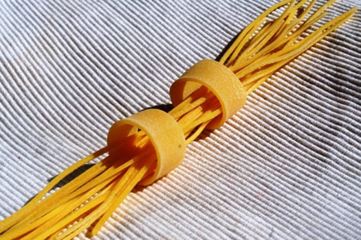 Macaroni and spaghetti on white tablecloth background