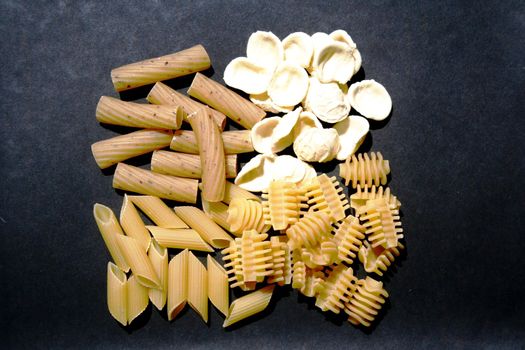 Variety of pasta on black background paper