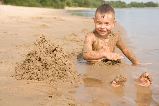 Boy on the beach digging himself