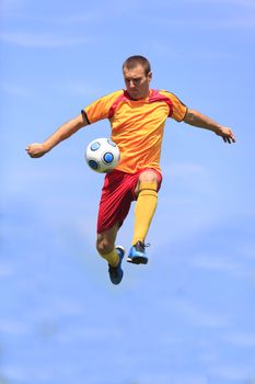Soccer player kicking the ball while jumping.