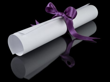 Diploma with a violet silk ribbon, isolated on black background.