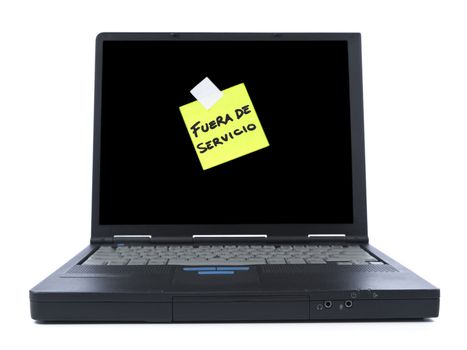 Black laptop with a sticky note in spanish meaning Out of Service. Isolated on white.