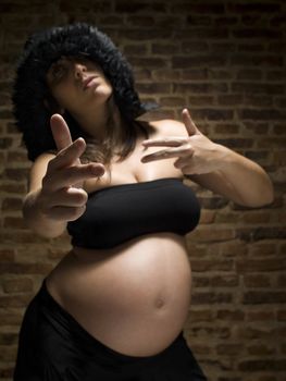 A young pregnant woman gesturing as she was armed. Focus on the hand.