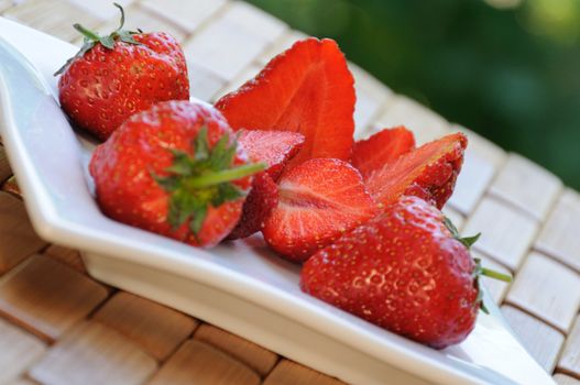 Sliced fresh strawberries on a plate close-up