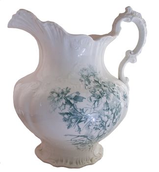 A green floral pitcher from an antique pitcher and basin set.