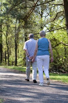 Lovely senior couple out for a walk in the woods on a summer afternoon