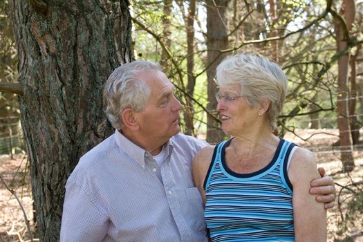 Lovely senior couple together on a sunny summer day out in the wood
