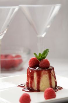 Delicious looking pannacotta dessert with raspberries and mint