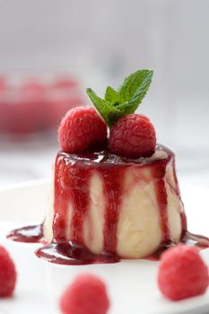 Delicious panna cotta dessert served with raspberries and a mint leave